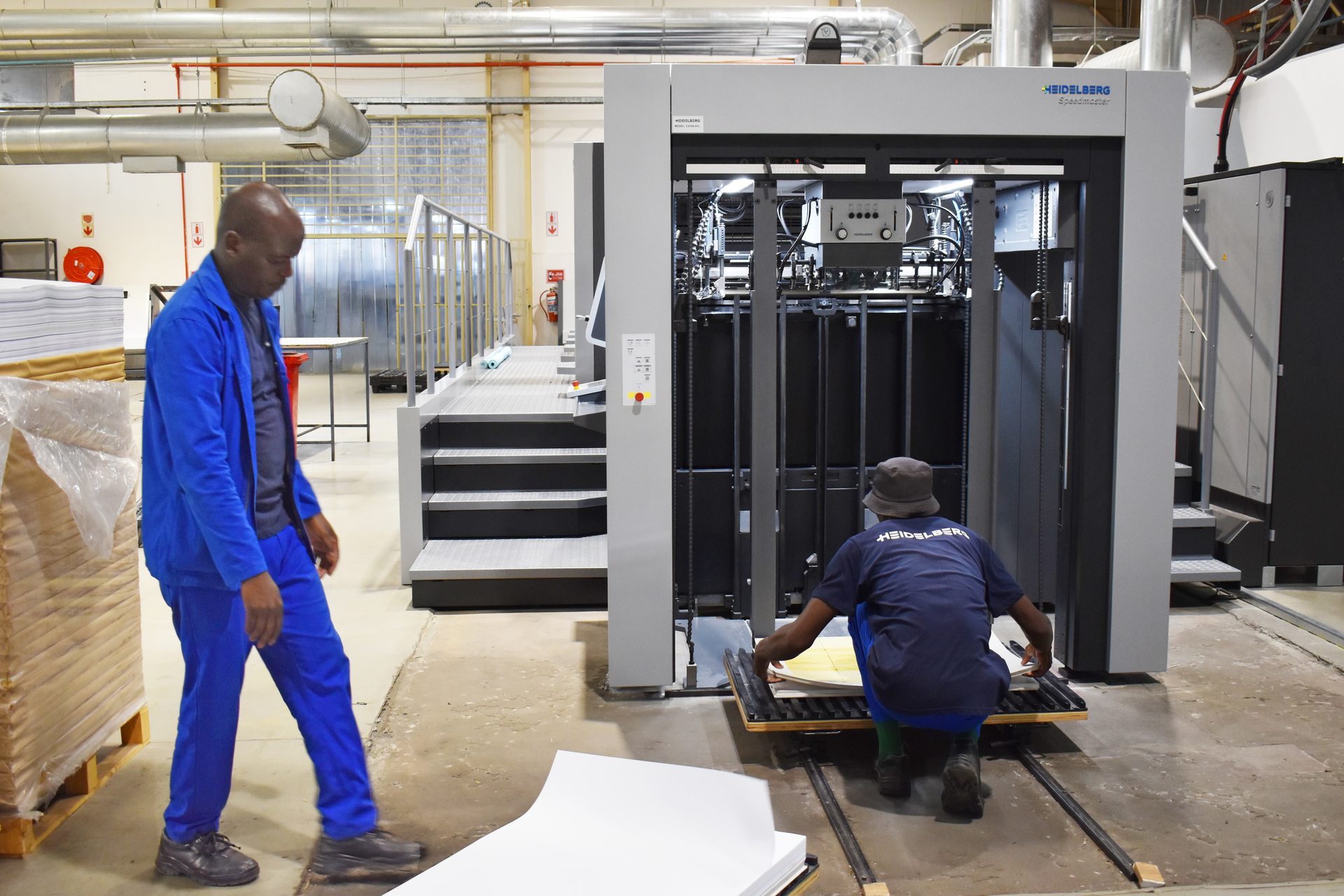 Operators running a large-format press